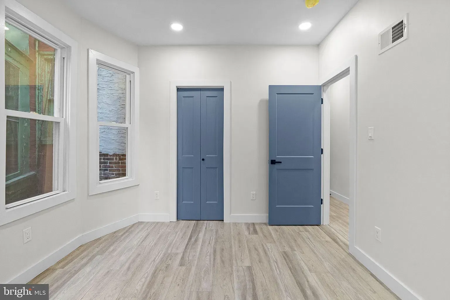 Unit A room with blue closet doors and a separate entry door