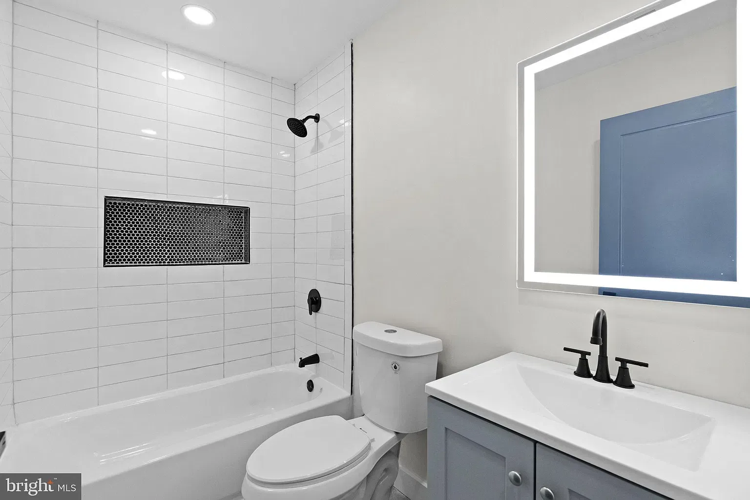 Unit B bathroom vanity and tiled tub area