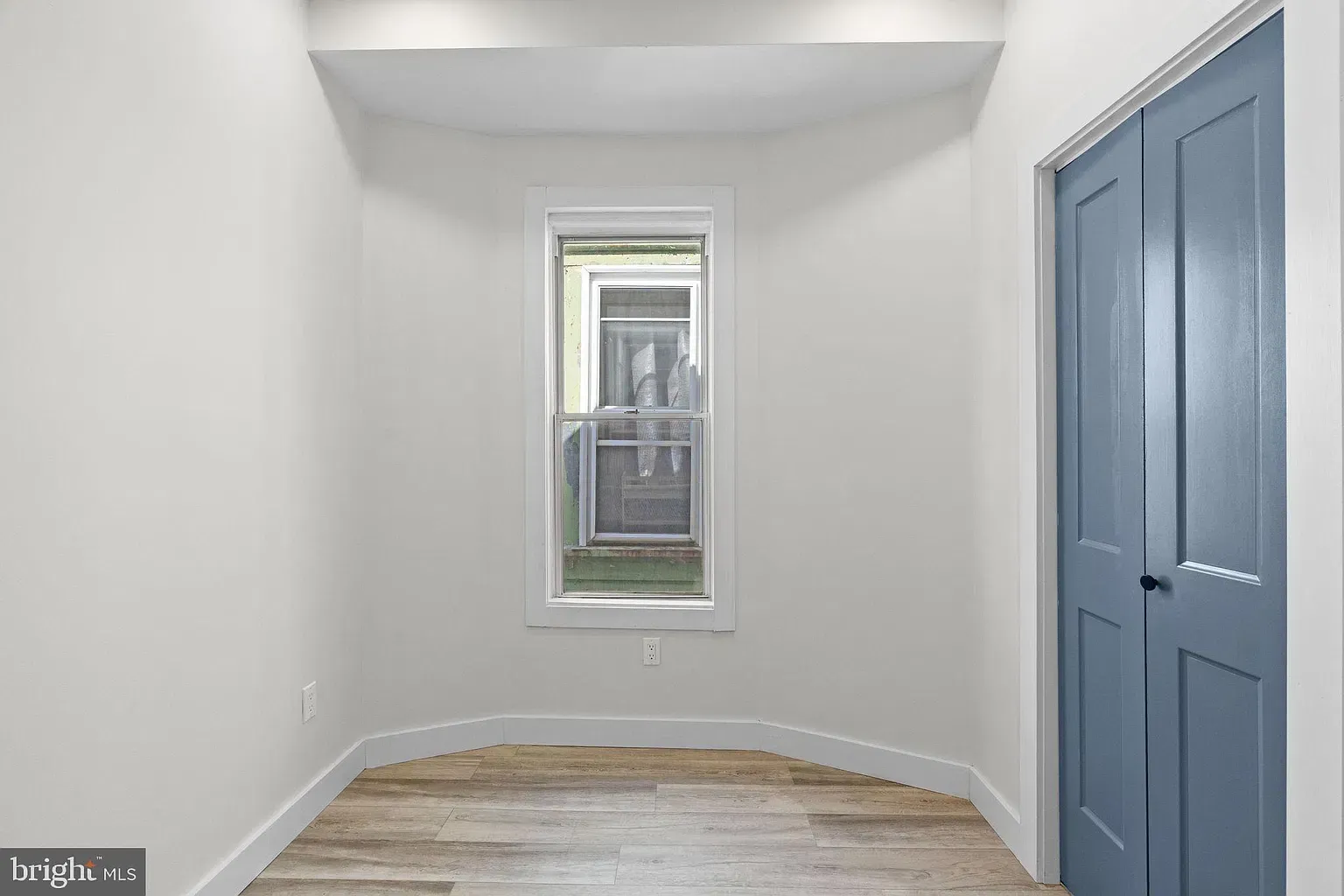 Bright Unit B room with a bay window and wood-look flooring