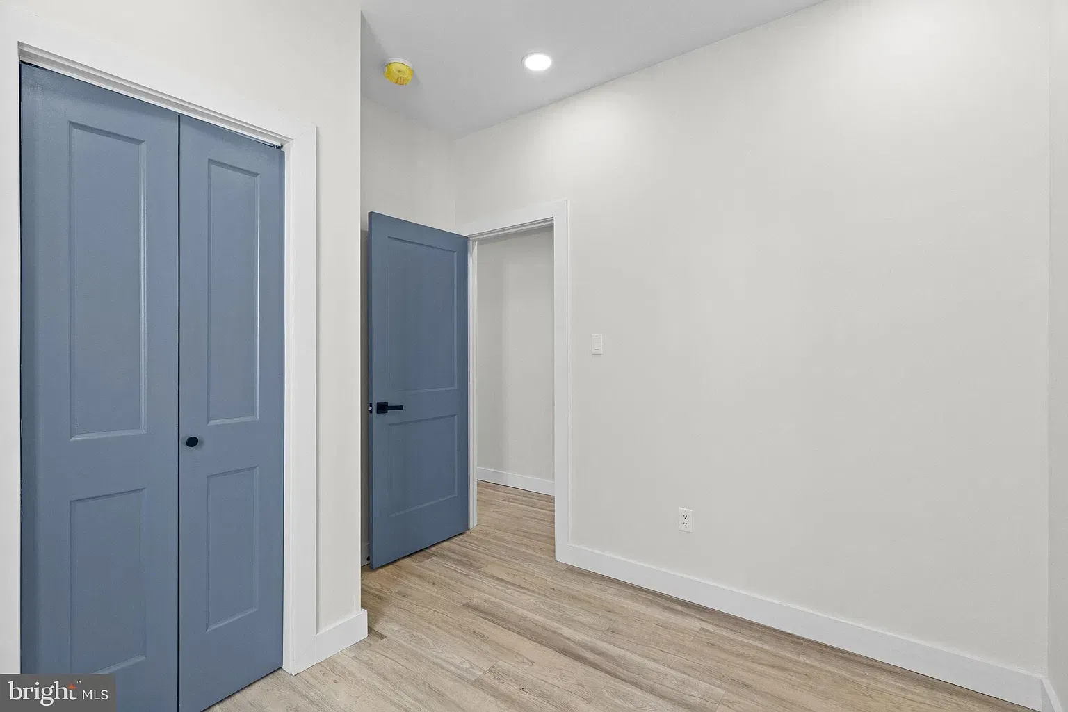Unit B bedroom with windows and light wood-look flooring