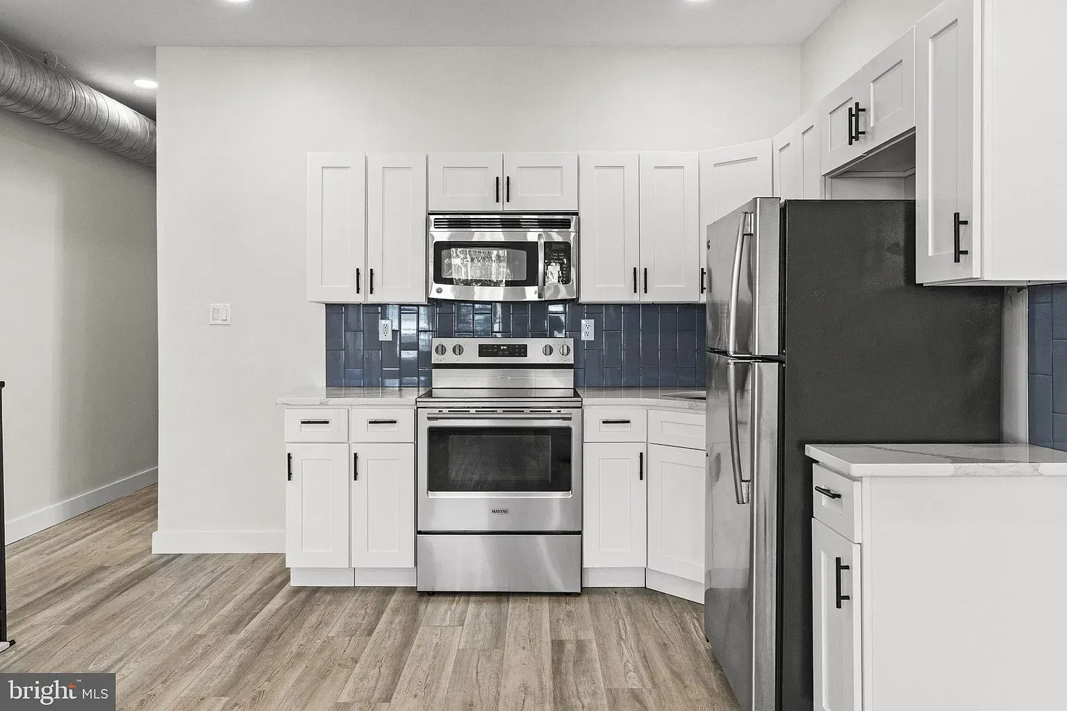Unit B kitchen opening into a bright dining and living area