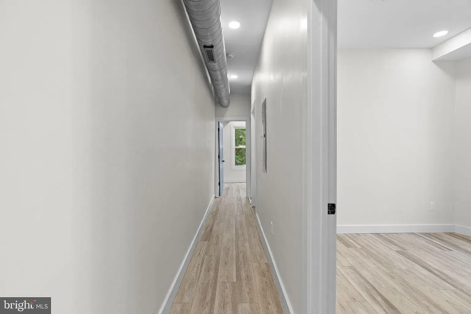 Unit B hallway beside laundry appliances and a bathroom vanity