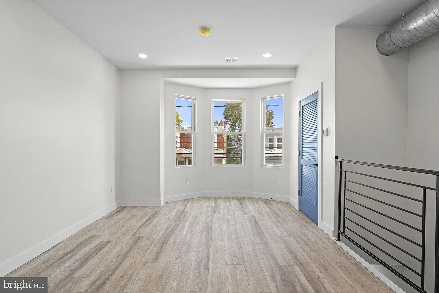 Unit B furnished living room and kitchen with blue interior door, stainless steel appliances, and dining area