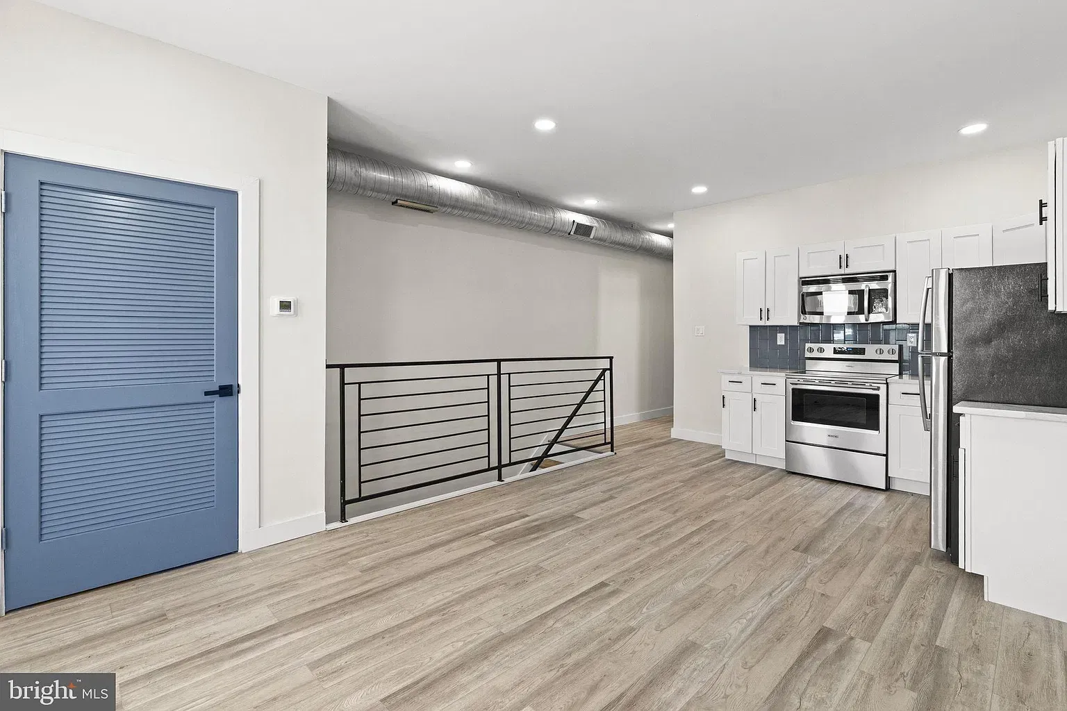 Staged Unit B open kitchen and living area with dining table and sofa