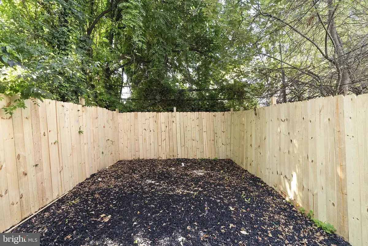 Private fenced yard with mature trees behind the property
